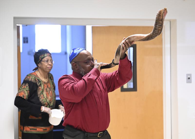 Ed Cook blows into a shofar, a traditional horn used to call people to assemble for Jewish religious purposes.